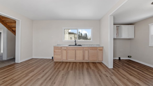 interior space with light brown cabinets, light hardwood / wood-style flooring, and sink