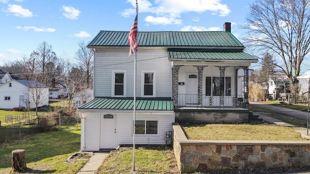 view of front facade with covered porch and a front yard