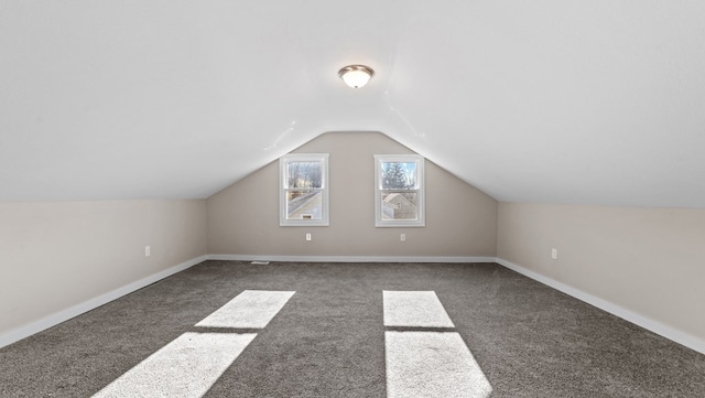 bonus room featuring dark colored carpet and lofted ceiling