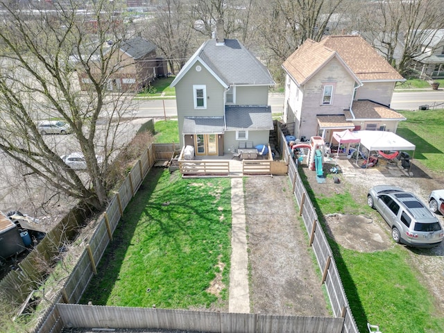 back of property featuring a lawn, a deck, and a fenced backyard