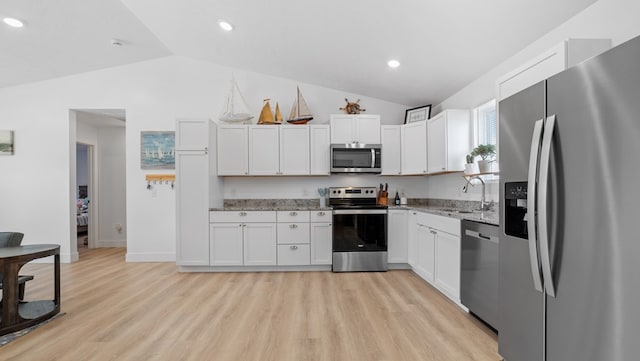 kitchen featuring appliances with stainless steel finishes, white cabinetry, a sink, and light wood-style flooring