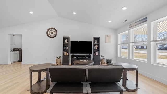 living room featuring vaulted ceiling, baseboards, visible vents, and light wood-style floors