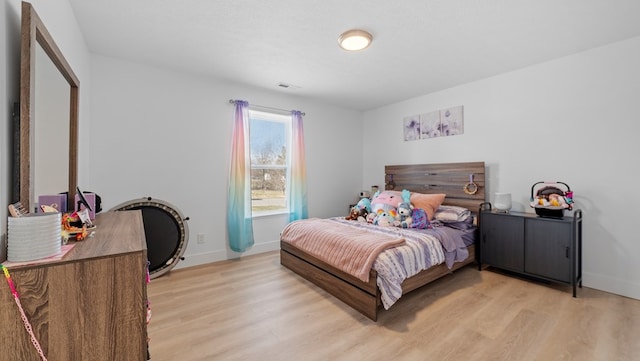 bedroom featuring visible vents, baseboards, a textured ceiling, and light wood finished floors