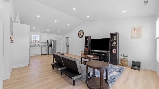 living area with lofted ceiling, light wood-style flooring, visible vents, and baseboards