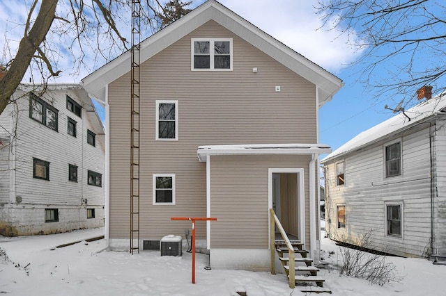 snow covered rear of property with central air condition unit