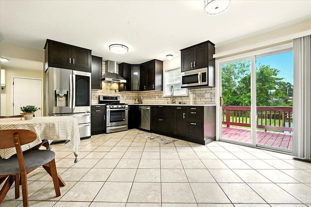 1645 Spring Village Ln, Mansfield, OH 44906 - kitchen featuring stainless steel appliances, wall chimney exhaust hood, light countertops, tasteful backsplash, and light tile patterned floors