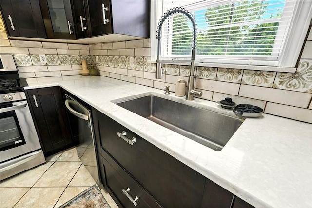 1645 Spring Village Ln, Mansfield, OH 44906 - kitchen with range, backsplash, dishwasher, light tile patterned floors, and dark cabinetry