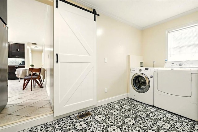1645 Spring Village Ln, Mansfield, OH 44906 - laundry room featuring a barn door, separate washer and dryer, ornamental molding, and light tile patterned flooring