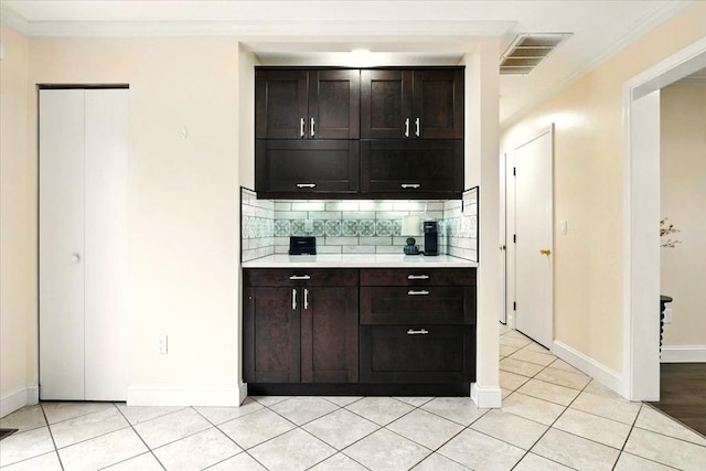 1645 Spring Village Ln, Mansfield, OH 44906 - bar area featuring tasteful backsplash, crown molding, and light tile patterned flooring