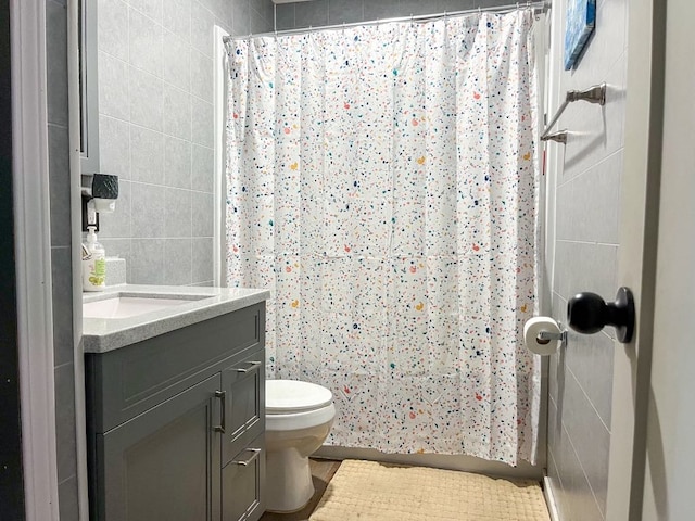 full bathroom featuring a shower with shower curtain, toilet, tile walls, and vanity