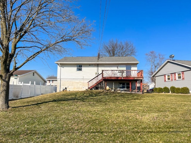 back of property with a lawn, a wooden deck, stairs, and fence