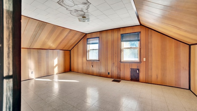 additional living space with wooden walls and lofted ceiling