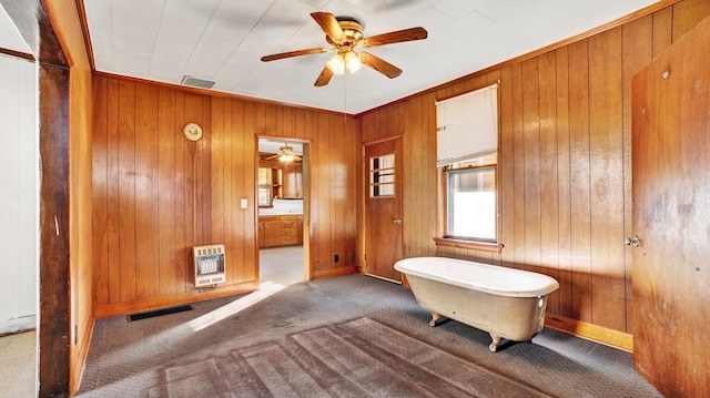 bathroom featuring a bathtub, ceiling fan, crown molding, and heating unit