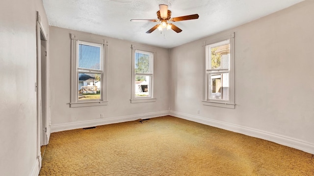 unfurnished room with carpet flooring, ceiling fan, and a textured ceiling