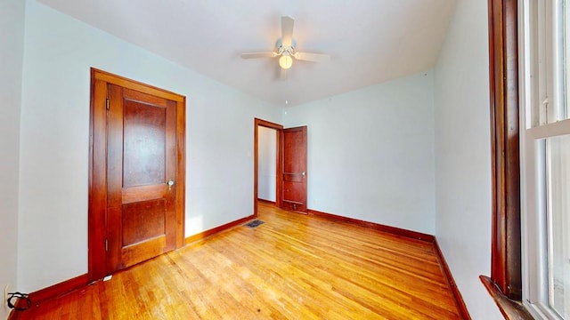 unfurnished bedroom with light wood-style flooring, baseboards, and ceiling fan