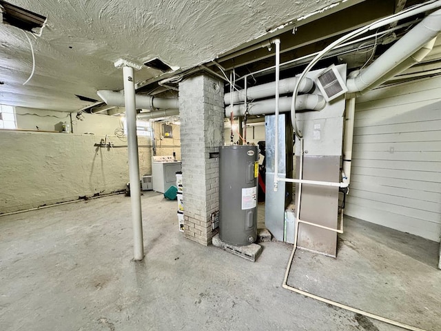 unfinished below grade area featuring water heater, visible vents, and washing machine and clothes dryer