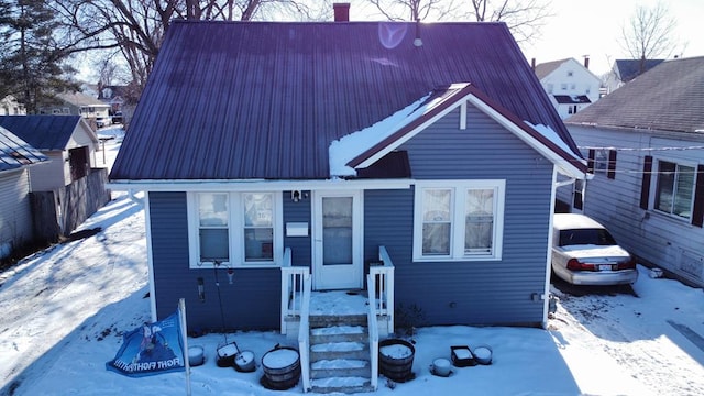 view of front facade with a chimney and metal roof