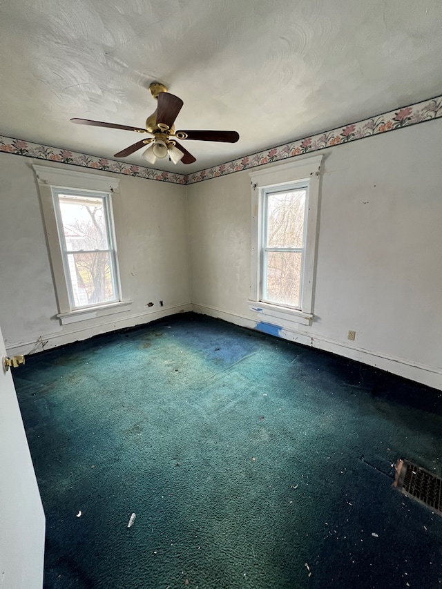 unfurnished room with a textured ceiling, carpet, and baseboards