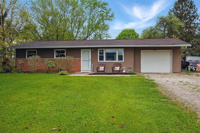 ranch-style home featuring brick siding, gravel driveway, a front lawn, and a garage