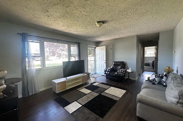 living area featuring wood-type flooring, a textured ceiling, and baseboards