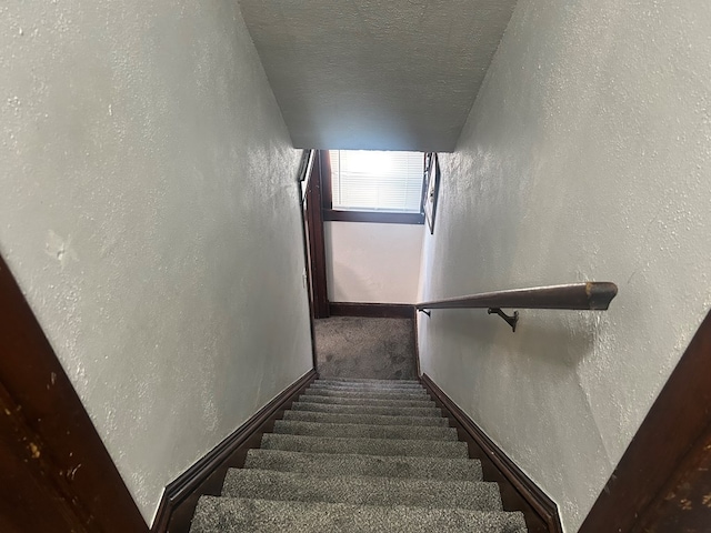 stairs with a textured ceiling