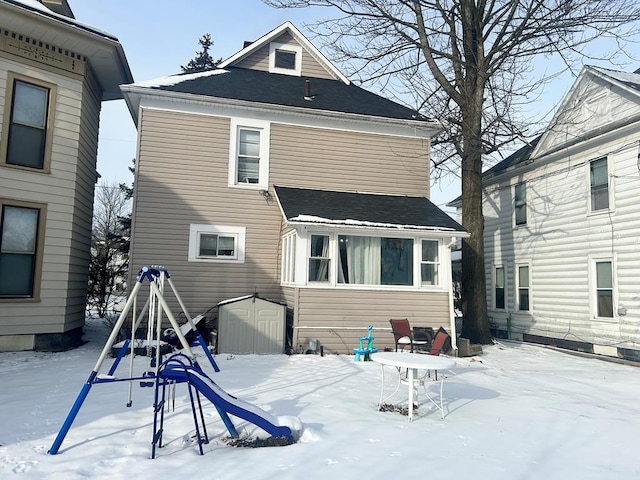 snow covered property with a storage unit