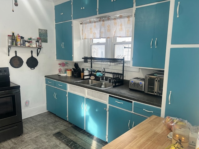 kitchen with blue cabinets, black range with electric cooktop, and sink