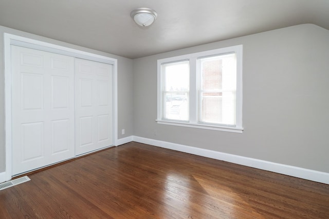 unfurnished bedroom featuring dark wood-type flooring and a closet