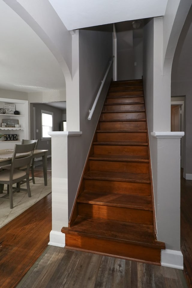 staircase featuring built in shelves and wood-type flooring