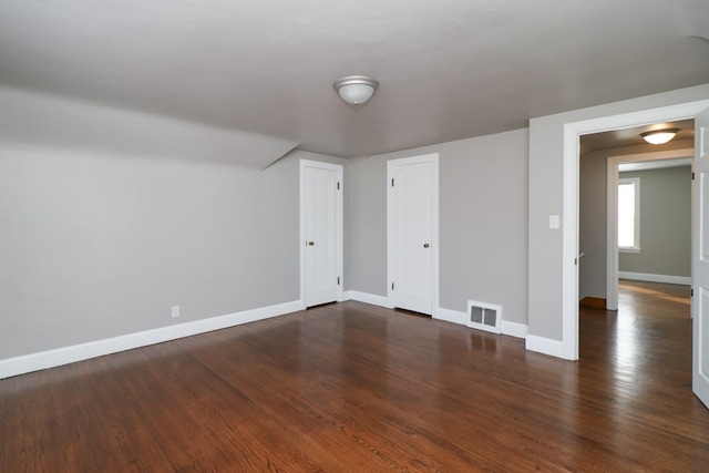 unfurnished room featuring dark wood-type flooring