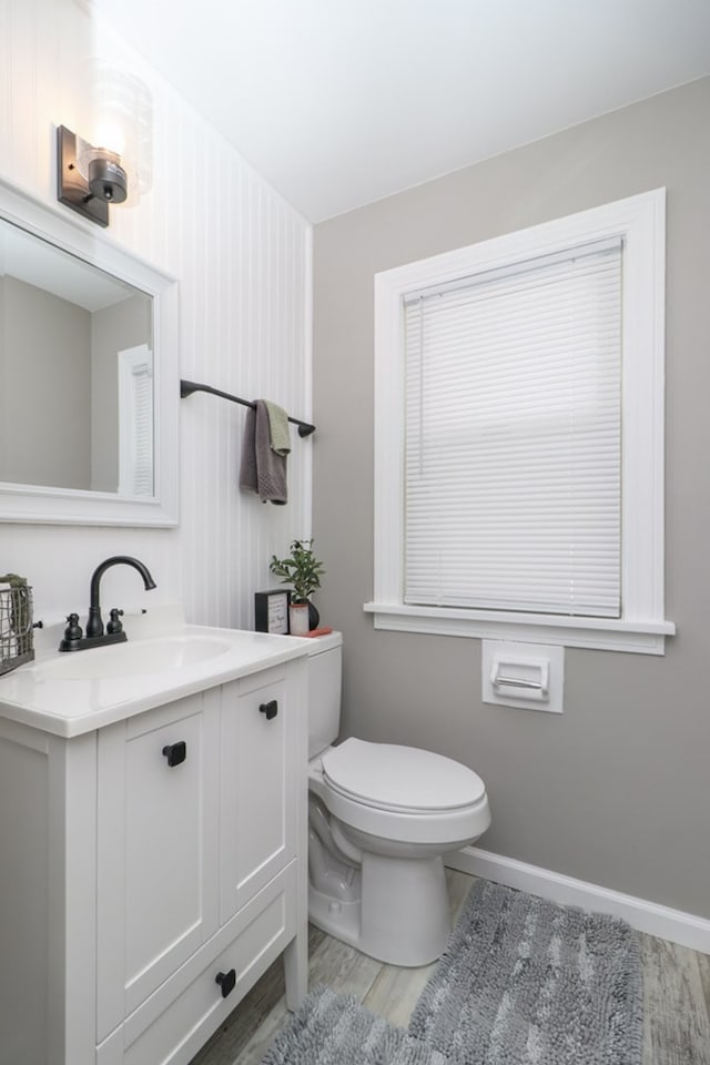 bathroom with vanity, toilet, and hardwood / wood-style floors