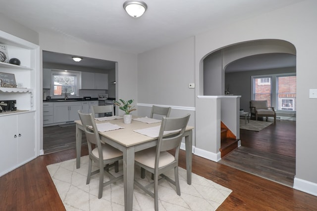 dining room with sink, wood-type flooring, and built in features