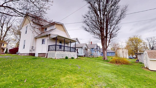 view of yard with a porch, an outbuilding, a residential view, and a shed