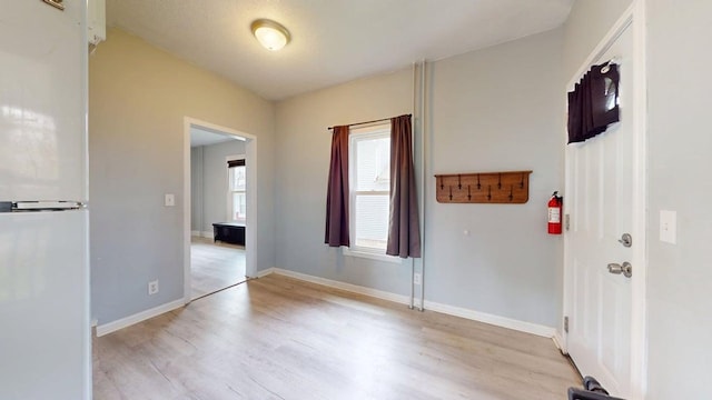 interior space with baseboards and light wood-style flooring