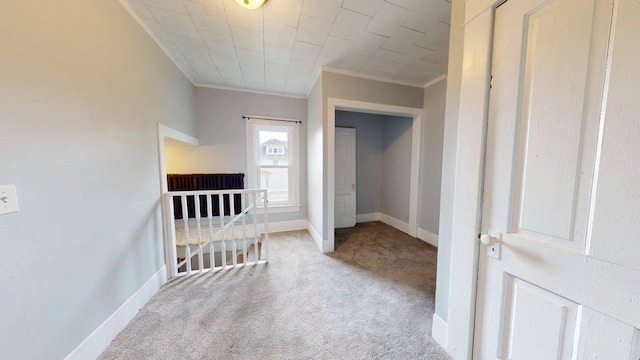 interior space featuring carpet, crown molding, and baseboards
