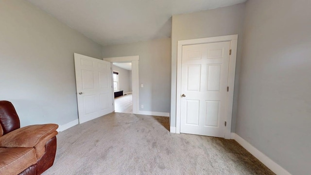 sitting room with baseboards and carpet flooring