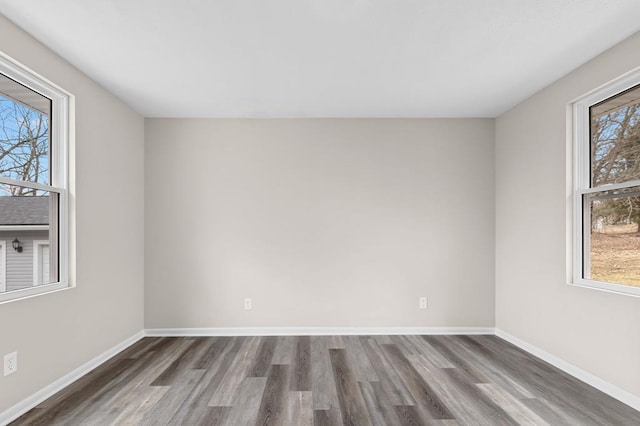 spare room featuring wood finished floors and baseboards