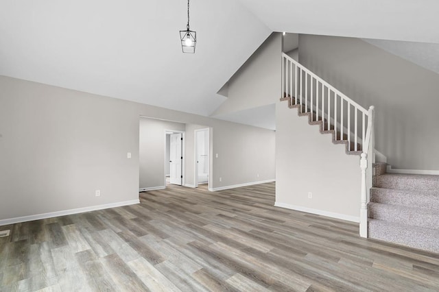 unfurnished living room featuring stairs, wood finished floors, and baseboards