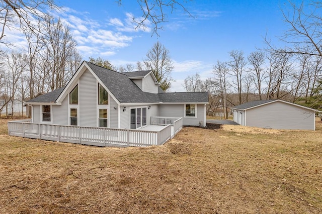 rear view of property featuring a lawn and a wooden deck