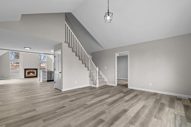 7326 State Route 19 Unit U3 L57-59, Mount Gilead, OH 43338 - unfurnished living room featuring stairs, high vaulted ceiling, wood finished floors, and a glass covered fireplace