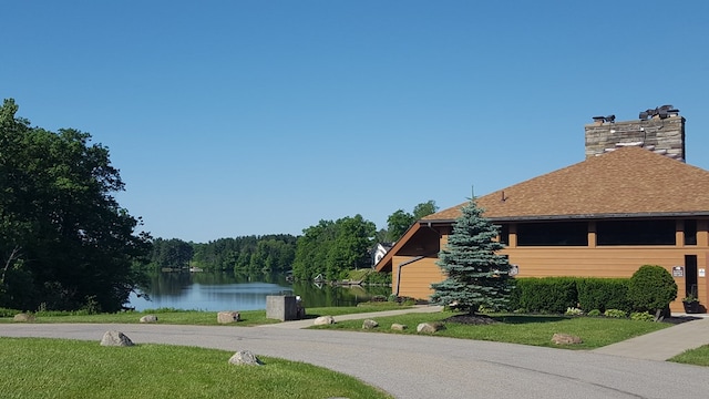 exterior space featuring a lawn and a water view