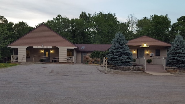 view of front facade featuring covered porch and gravel driveway