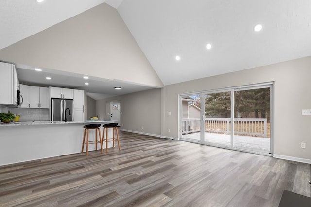 kitchen featuring light wood-style flooring, a peninsula, white cabinetry, light countertops, and appliances with stainless steel finishes