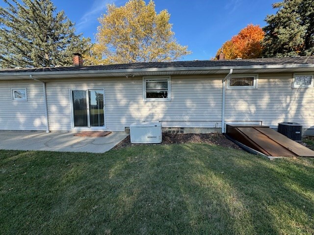 rear view of house featuring a lawn, a patio area, and cooling unit