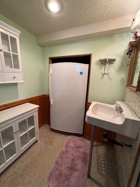 bathroom featuring wooden walls and a textured ceiling