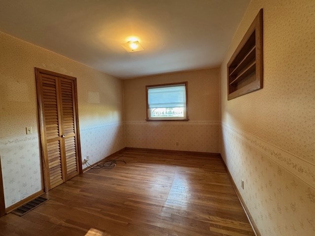 unfurnished bedroom featuring a closet and dark hardwood / wood-style flooring