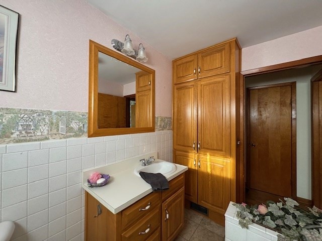 bathroom with tile patterned flooring, vanity, and tile walls