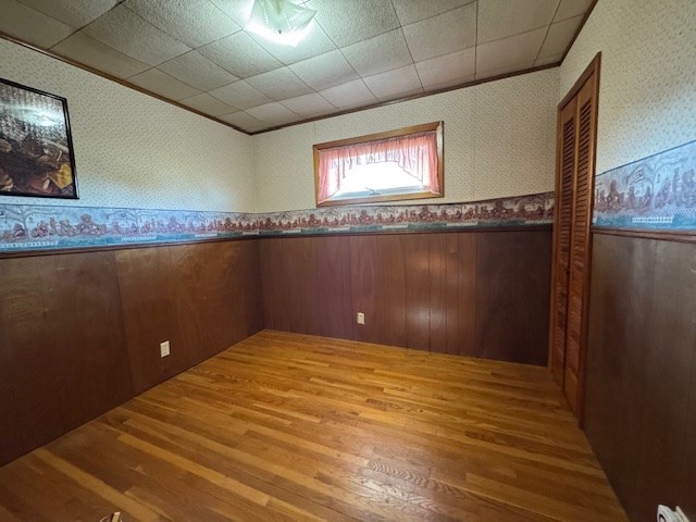 empty room with hardwood / wood-style flooring and ornamental molding