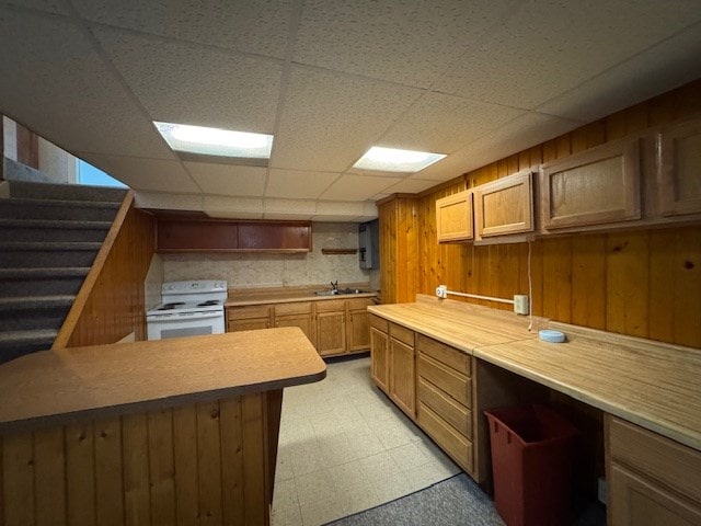 kitchen with a paneled ceiling, white range, and sink