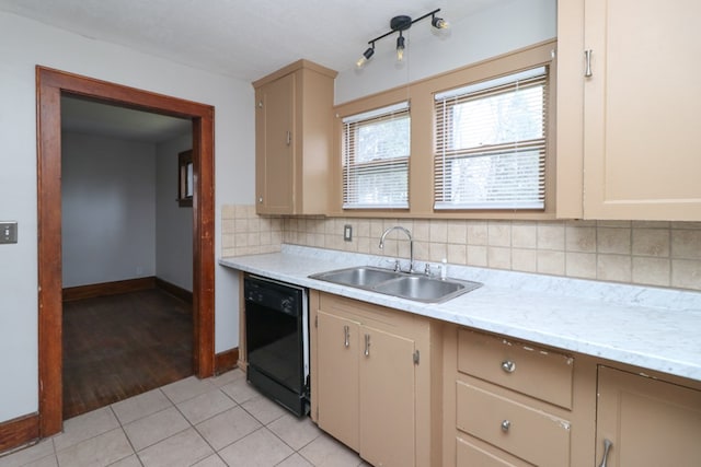 kitchen featuring a sink, backsplash, light tile patterned floors, baseboards, and dishwasher